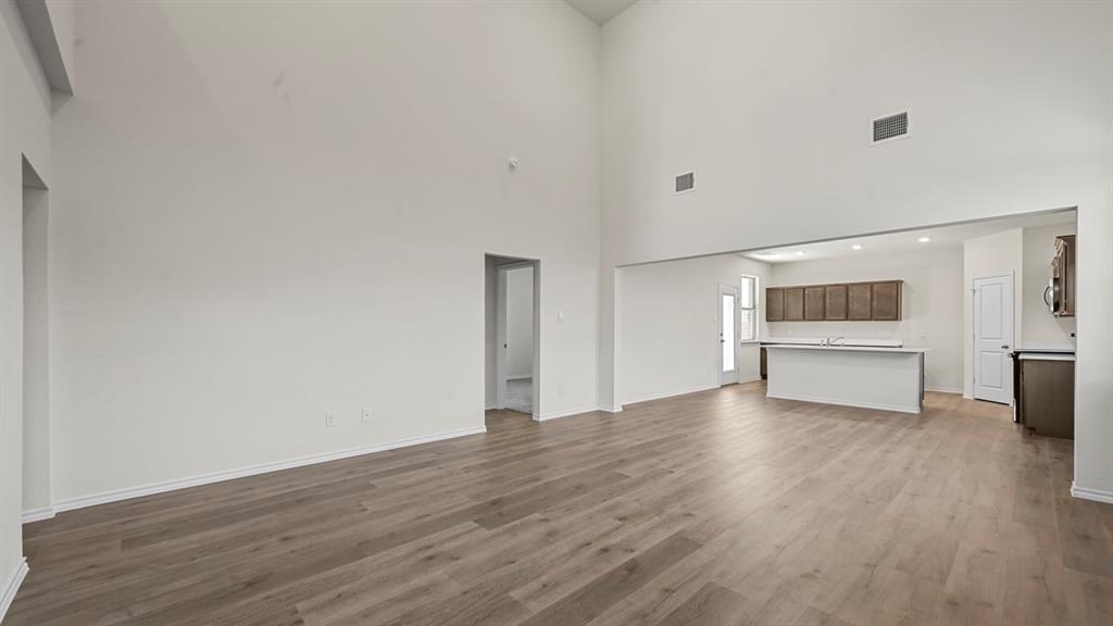 650 Glee Stem Road Lavon, TX 75166 - Photo 11 of 22 a view of an empty room with a window and wooden floor