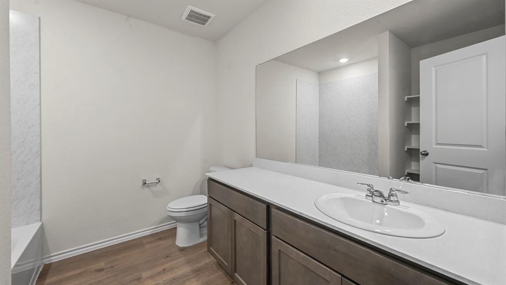 650 Glee Stem Road Lavon, TX 75166 - Photo 16 of 22 a bathroom with a sink a toilet and a mirror