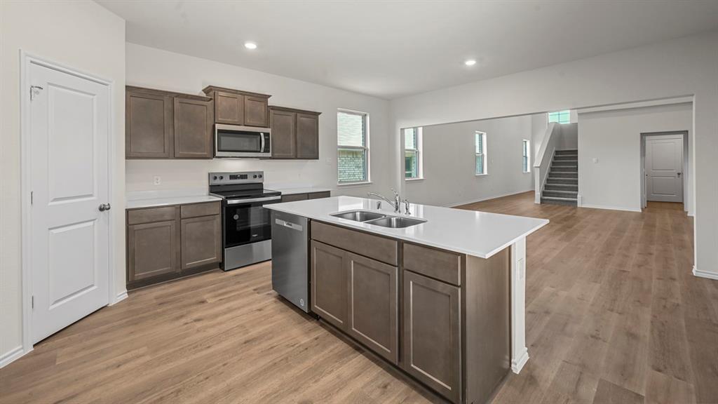 650 Glee Stem Road Lavon, TX 75166 - Photo 3 of 22 a kitchen with a sink cabinets and wooden floor