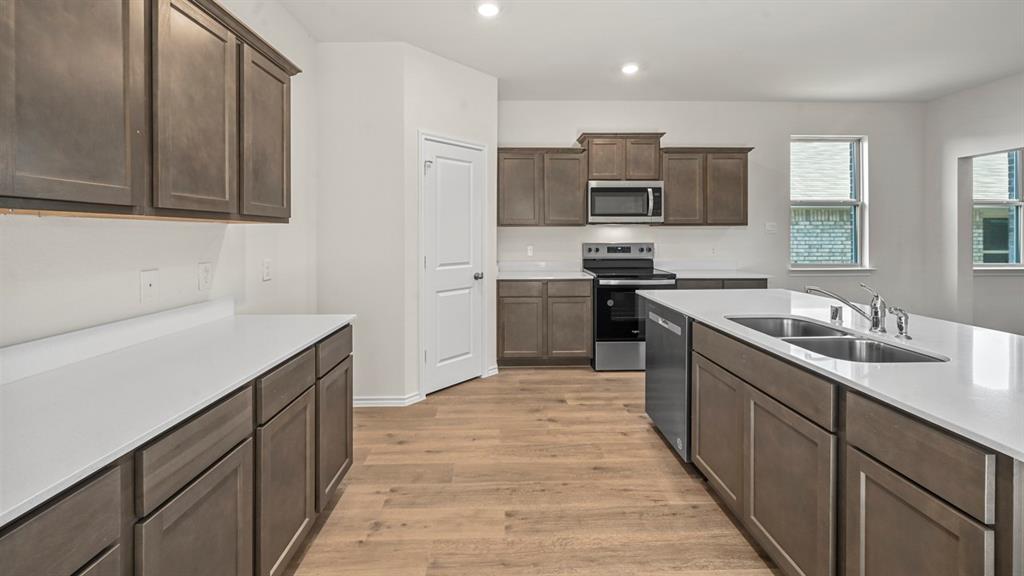 650 Glee Stem Road Lavon, TX 75166 - Photo 4 of 22 a kitchen with stainless steel appliances granite countertop a sink stove and refrigerator