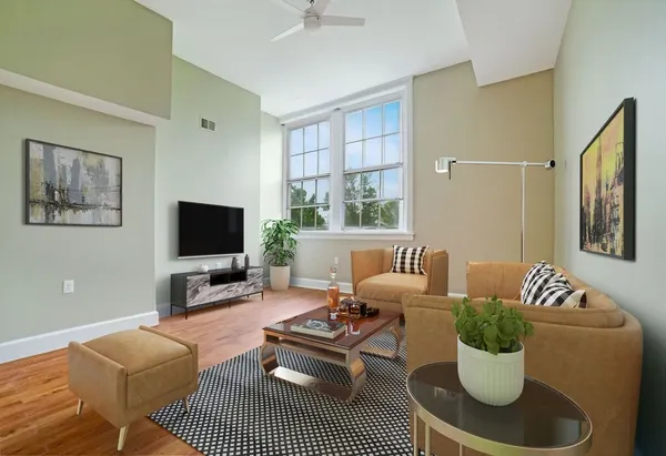 a living room with furniture a flat screen tv and a window