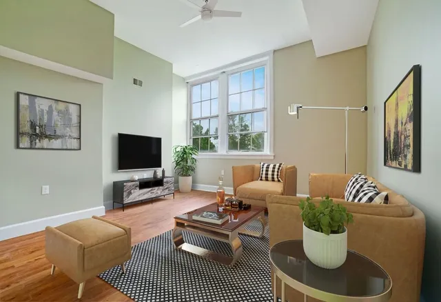 a living room with furniture a flat screen tv and a window