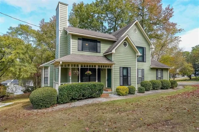 a view of a house with a yard and potted plants