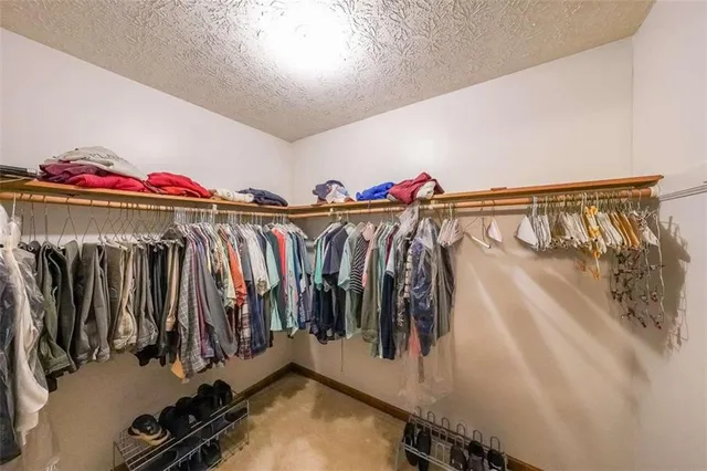 a view of walk in closet with clothes and shoes