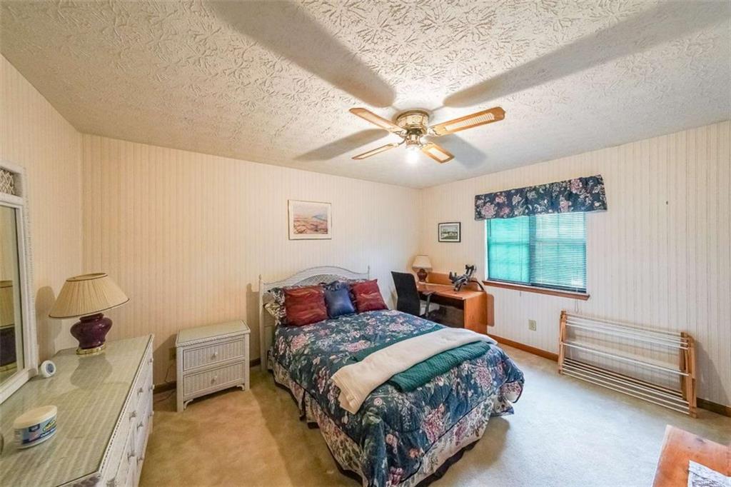 183 Timothy Lane Northwest Lilburn, GA 30047 - Photo 20 of 32 a bedroom with a bed and a chandelier