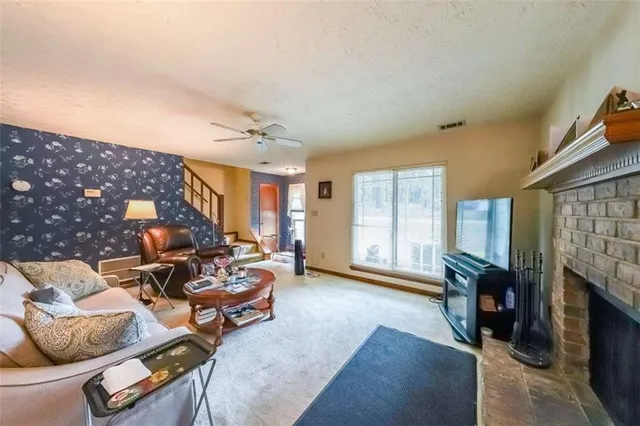 a living room with furniture a fireplace and a large window