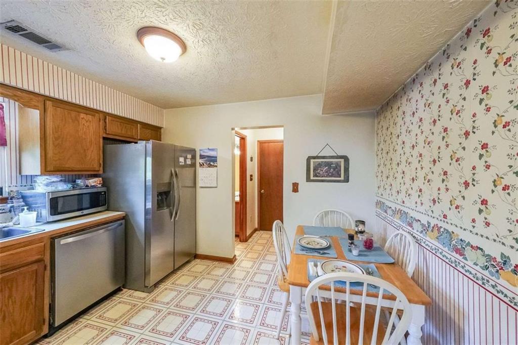 183 Timothy Lane Northwest Lilburn, GA 30047 - Photo 8 of 32 a kitchen with stainless steel appliances granite countertop a refrigerator a sink a stove top oven with wooden floor