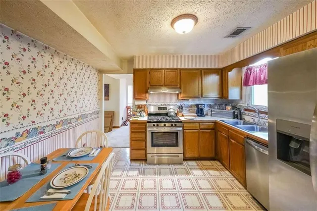 a kitchen with stainless steel appliances granite countertop a sink and cabinets