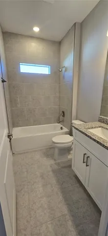 a bathroom with a granite countertop sink a toilet and shower