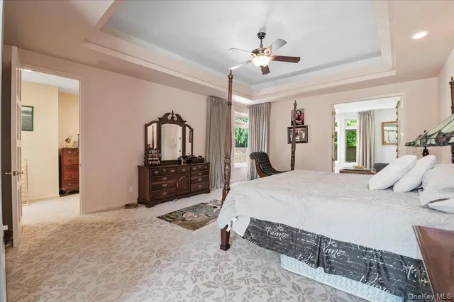 a spacious bedroom with a bed a chandelier and a dresser