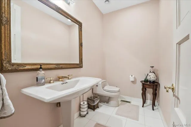 a bathroom with a sink toilet and a mirror