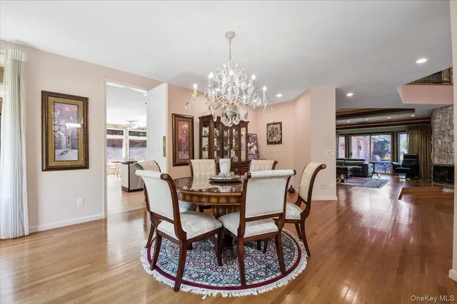 a dining room with furniture a chandelier and wooden floor