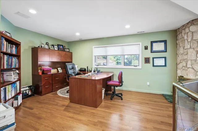 a living room with furniture a bookshelf and a flat screen tv