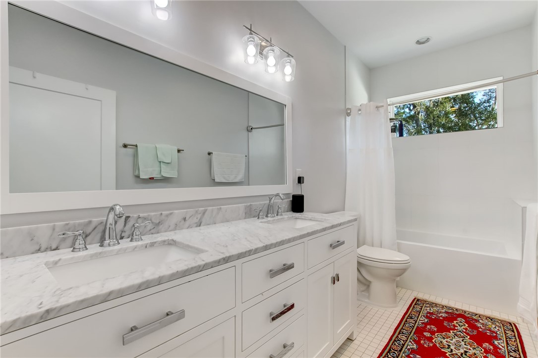 521 Bonnieview Road Fernandina Beach, FL 32034 - Photo 22 of 35 a bathroom with a granite countertop sink a toilet a large mirror a vanity and shower