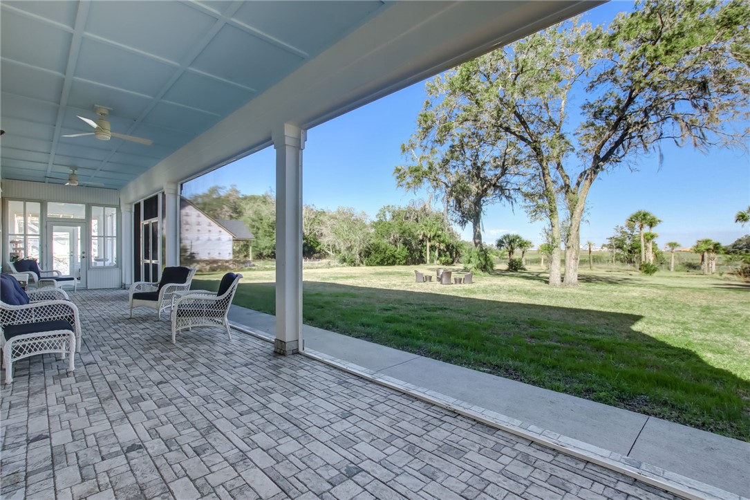 521 Bonnieview Road Fernandina Beach, FL 32034 - Photo 28 of 35 a view of a chair and tables in the patio next to a yard