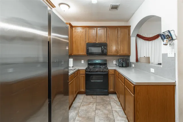 a kitchen with stainless steel appliances granite countertop a stove a sink and a refrigerator