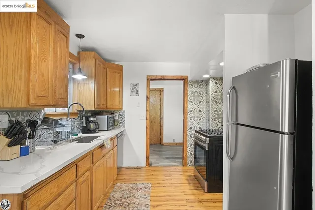 a kitchen with a refrigerator sink and cabinets