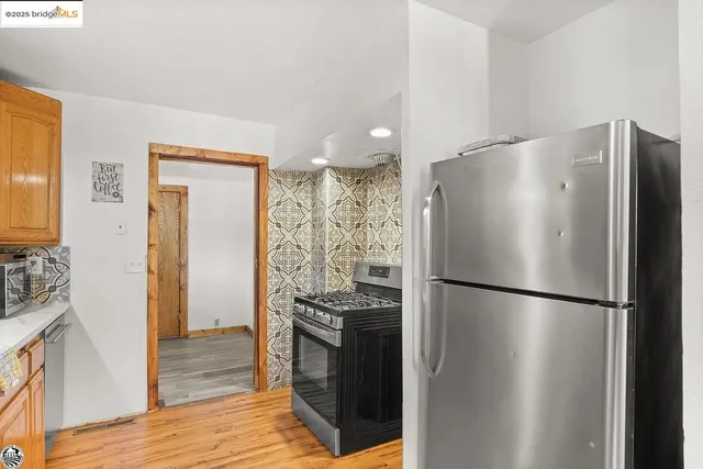 a kitchen with stainless steel appliances a refrigerator and a stove top oven