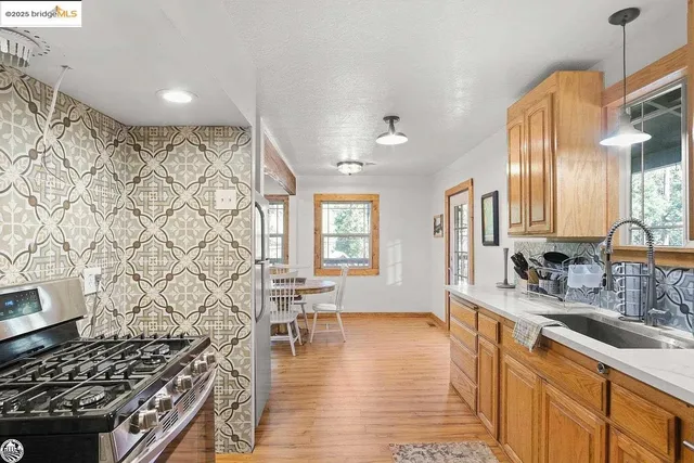 a kitchen with stainless steel appliances granite countertop a sink stove and cabinets