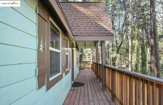 a view of a balcony with wooden floor and fence