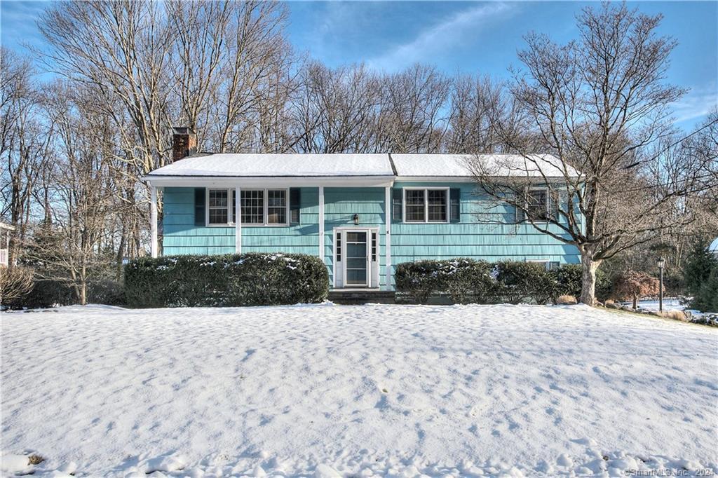 a front view of a house with a yard covered in snow