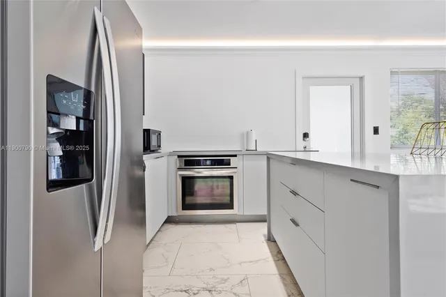 a kitchen with stainless steel appliances granite countertop a refrigerator and a sink
