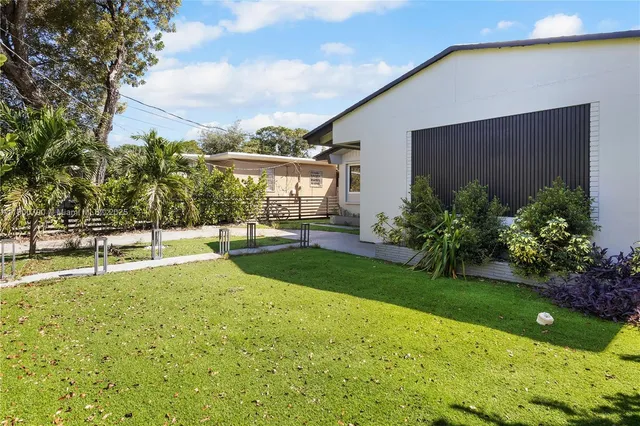 a view of backyard with swimming pool and green space