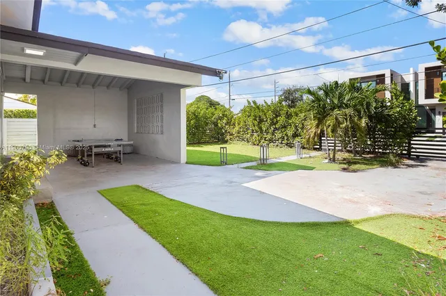 a view of a backyard with table and chairs under an umbrella