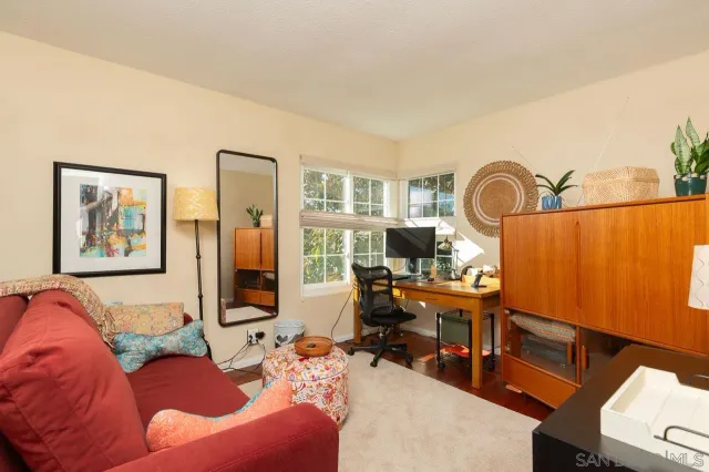 a living room with furniture a rug and white walls