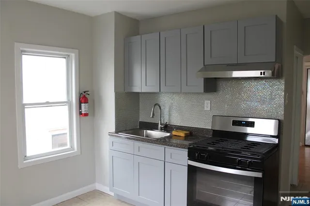 a kitchen with granite countertop a sink stove and cabinets