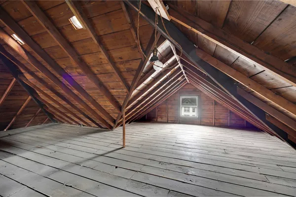 a view of an empty room with window and a chandelier fan