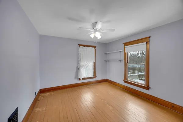 a view of a room with wooden floor and windows