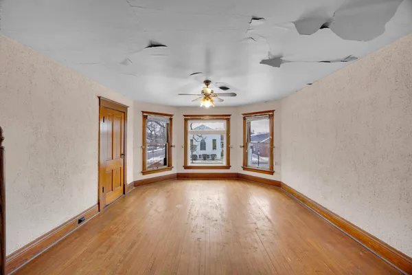 a view of an empty room with window and wooden floor