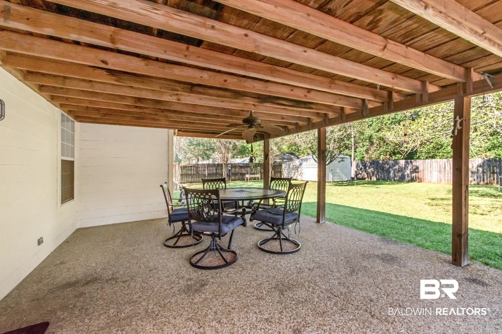 1345 Camden Court Mobile, AL 36695 - Photo 18 of 31 Fenced backyard with a patio, a storage unit, outdoor dining area, and a ceiling fan