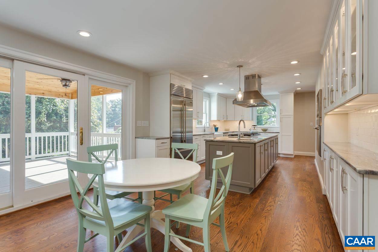 316 Kent Road Charlottesville, VA 22903 - Photo 14 of 47 a kitchen with a table chairs wooden floors and white cabinets