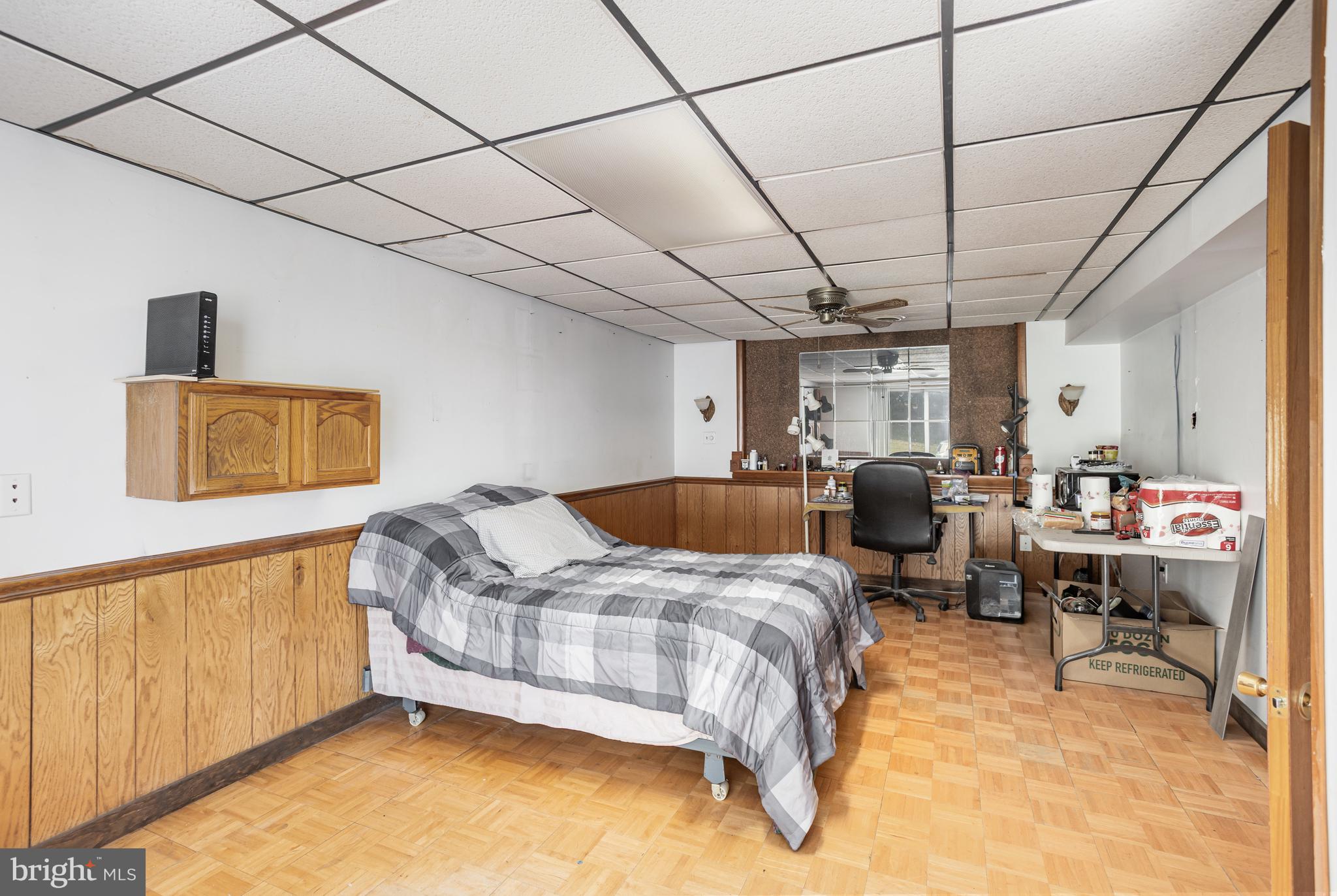 1487 Kbs Road Spring Grove, PA 17362 - Photo 22 of 35 a bedroom with a bed a desk and chair with wooden floor