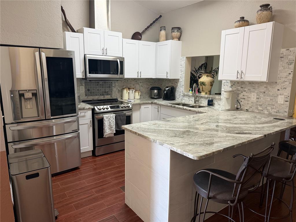 2700 Verna Bethany Road Myakka City, FL 34251 - Photo 17 of 61 a kitchen with stainless steel appliances granite countertop a stove refrigerator sink and microwave