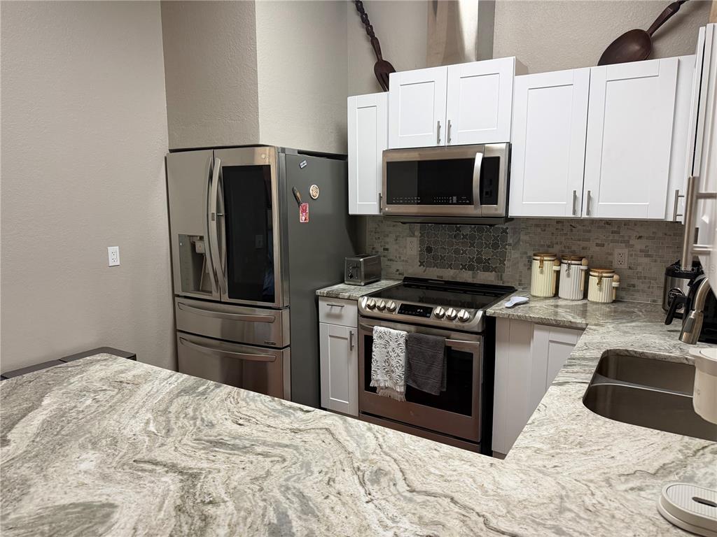 2700 Verna Bethany Road Myakka City, FL 34251 - Photo 19 of 61 a kitchen with stainless steel appliances granite countertop a refrigerator stove and microwave