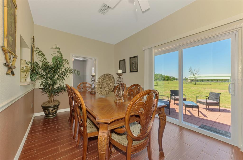 2700 Verna Bethany Road Myakka City, FL 34251 - Photo 22 of 61 a dining room with furniture large windows and wooden floor