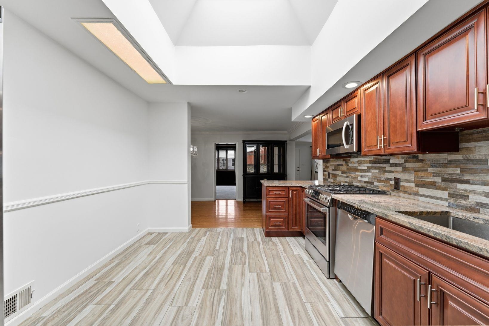 229 Centre Avenue Secaucus, NJ 07094 - Photo 11 of 40 a kitchen with stainless steel appliances granite countertop a stove cabinets and wooden floor