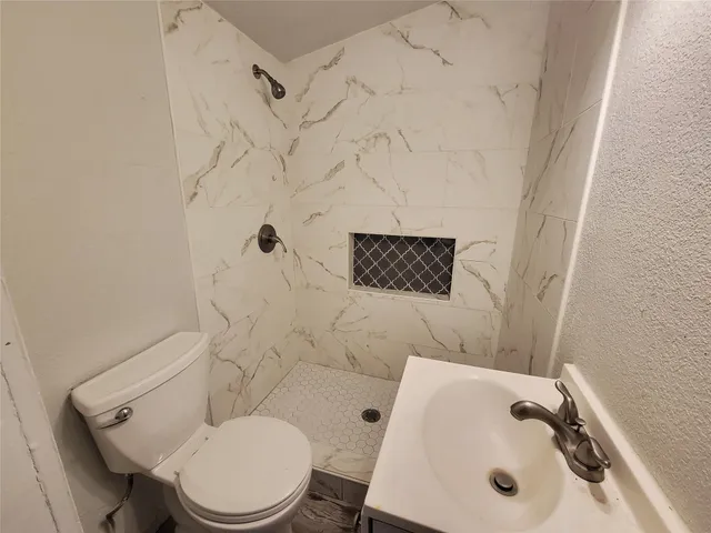 a bathroom with a sink toilet and shower