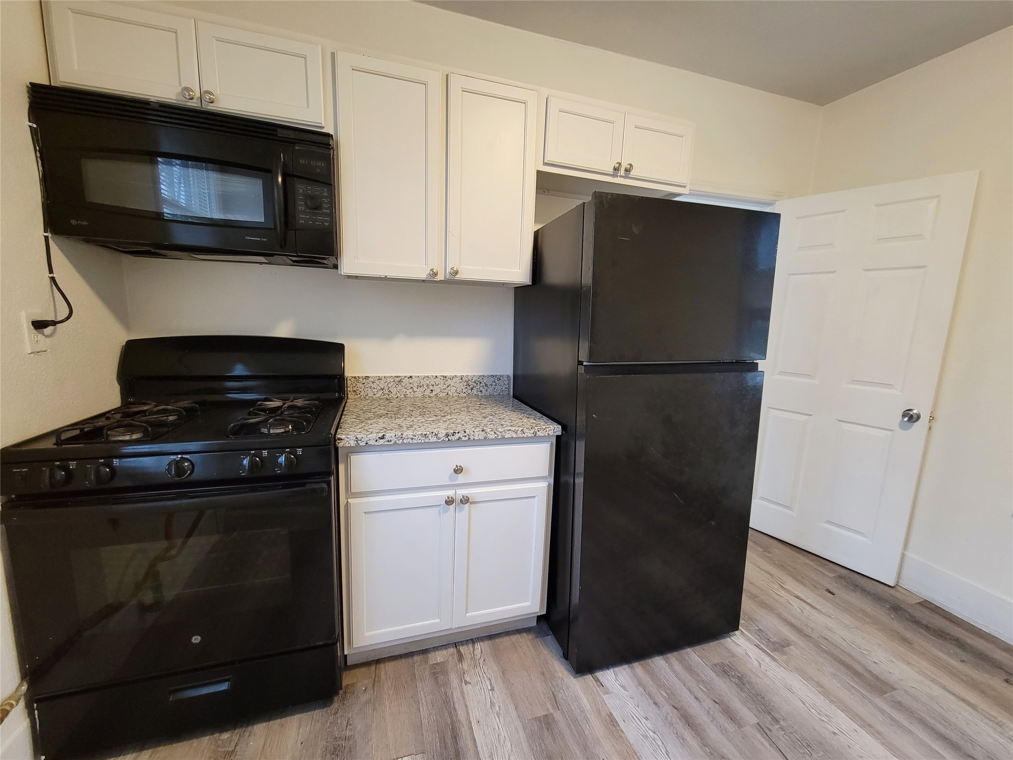 3913 Winnie Street, Unit UP Galveston, TX 77550 - Photo 6 of 9 a kitchen with a stove microwave and refrigerator
