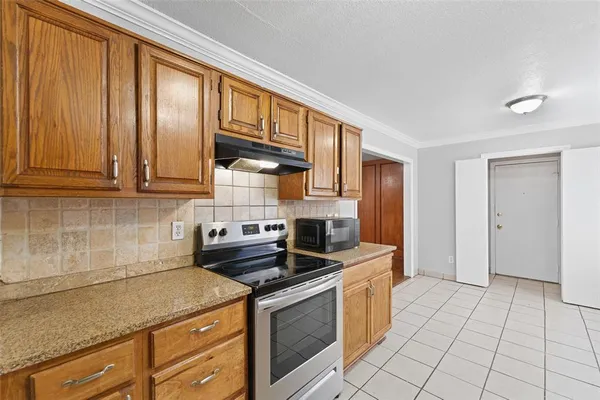 a kitchen with stainless steel appliances granite countertop a stove a sink and a microwave