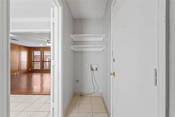 a view of a hallway with wooden floor and a bathroom