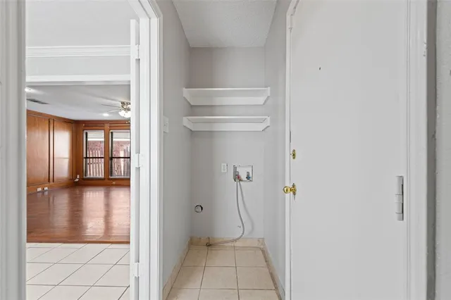 a view of a hallway with wooden floor and a bathroom