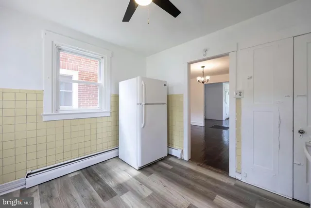 a view of empty room with window and refrigerator