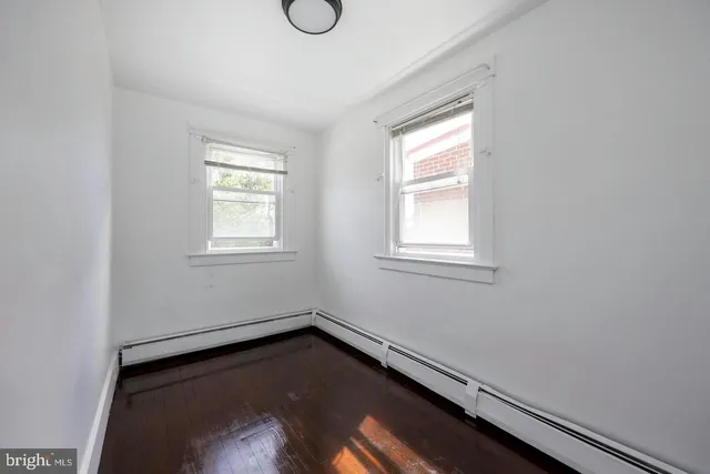 a view of a room with wooden floor and windows