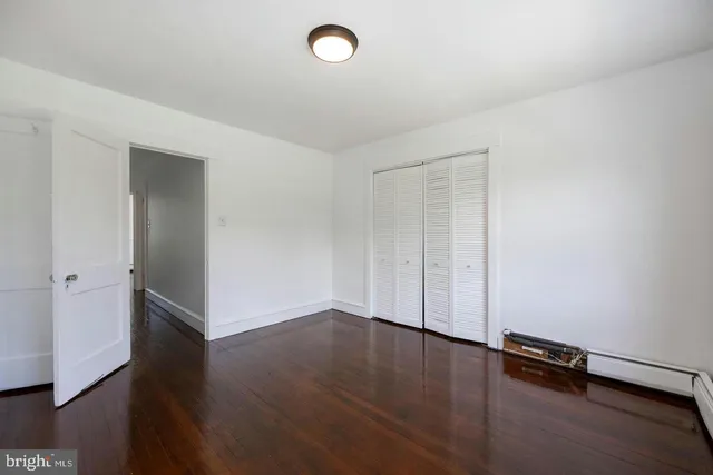 an empty room with wooden floor and window