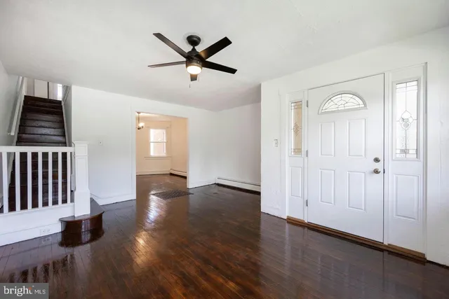 an empty room with wooden floor cabinet and windows