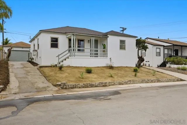 a view of a white house with a big yard and large tree
